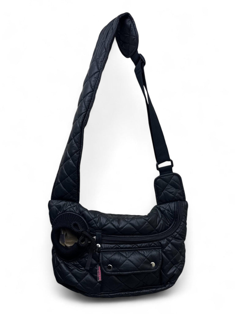 Small dog inside black waterproof sling bag with cozy beige interior